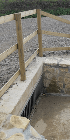 Davis Groundworks | A wooden fence is surrounding a stone wall.