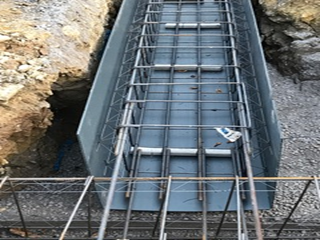 A metal structure is being built in a hole in the ground.