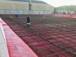 A building under construction with a red roof