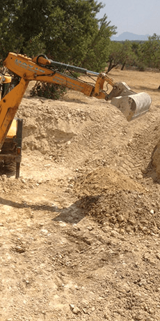 A bulldozer is digging a hole in the dirt in a field.