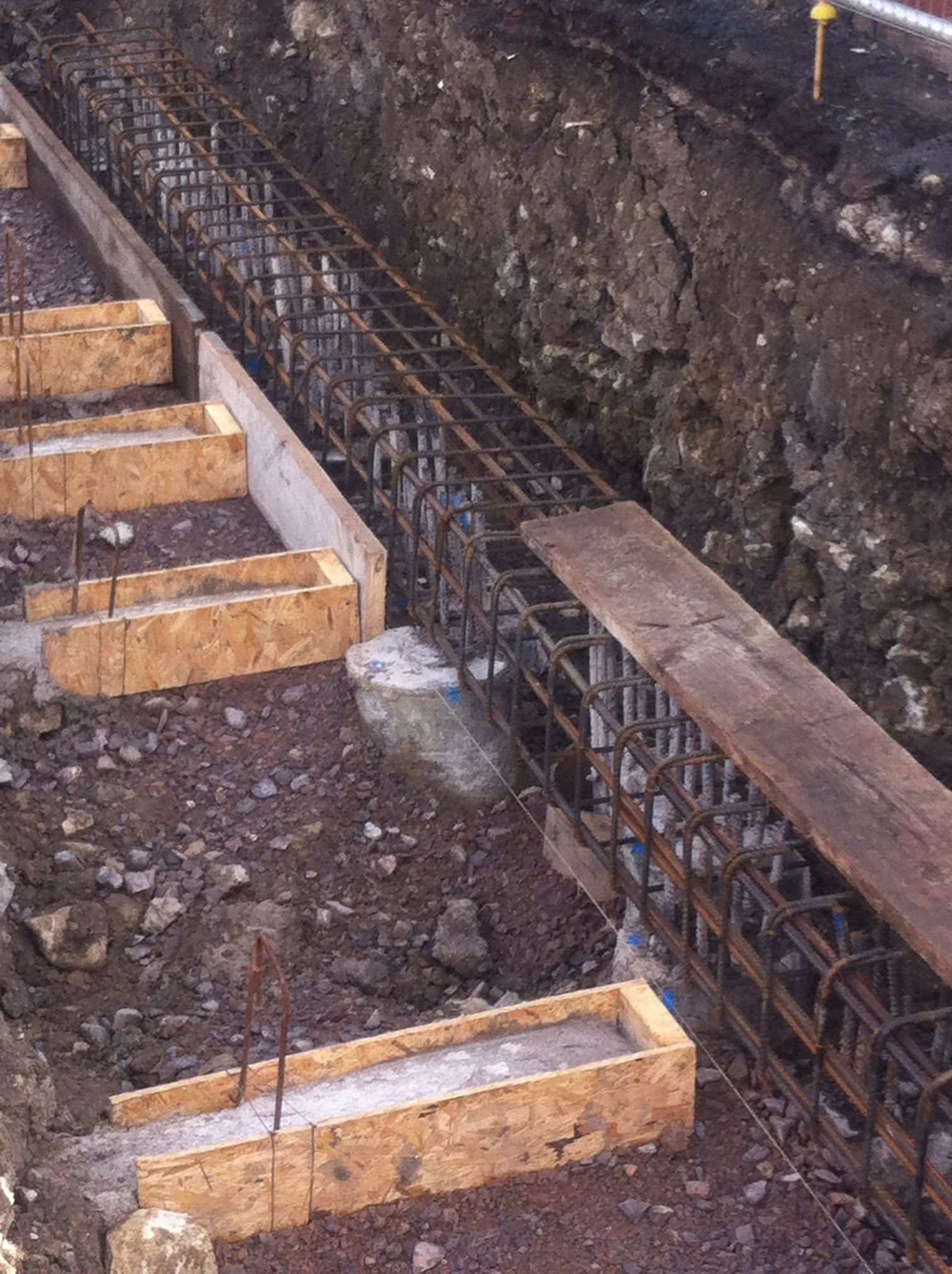 A row of wooden boxes are sitting in the dirt