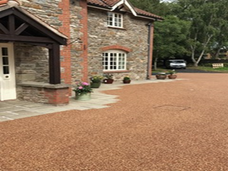 A stone house with a driveway in front of it