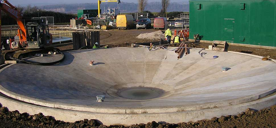 A construction site with a green building in the background