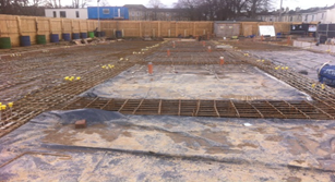 A large concrete slab is being built on a construction site.