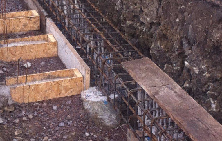 A wooden plank is sitting on the ground next to a metal structure.