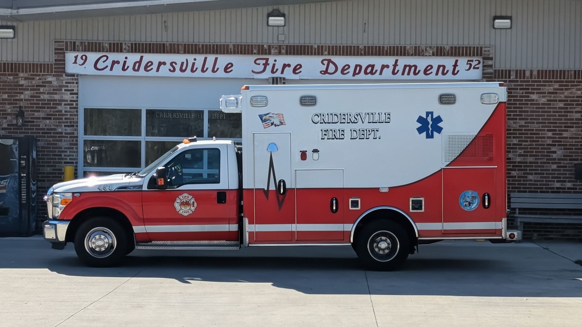 Ambulance for Crisfield Fire Dept. in front of a brick building.