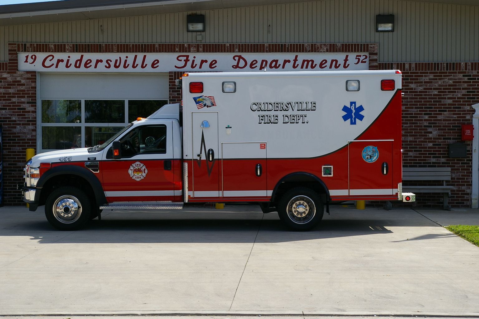 Ambulance for Crisfield Fire Dept. in front of a brick building.