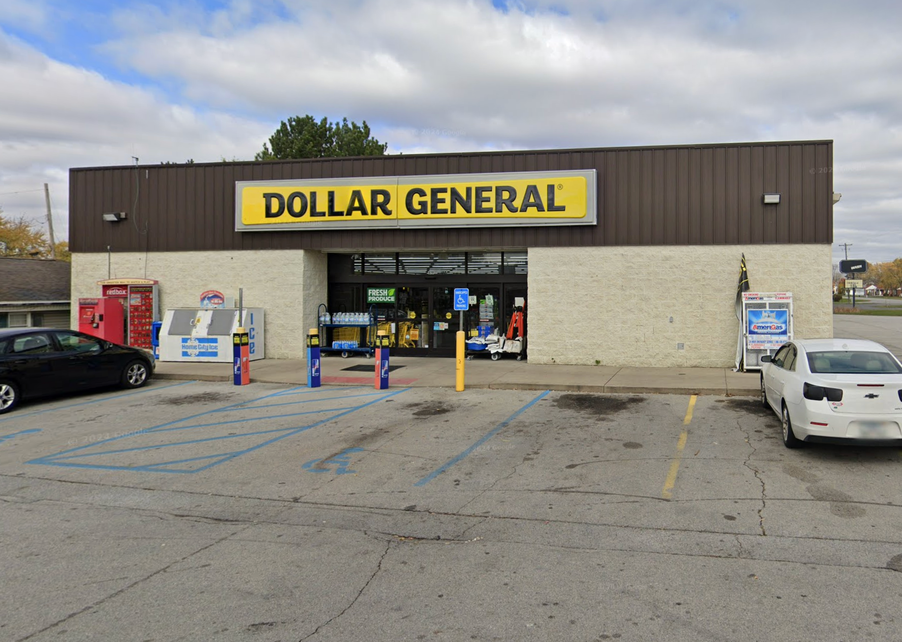 Dollar General store exterior with yellow sign, beige brick wall, parking lot.