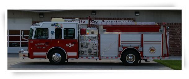 Fire truck parked in front of a building; red and white colors.
