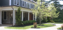 Two-story house with a covered porch, brick exterior, and landscaped front yard