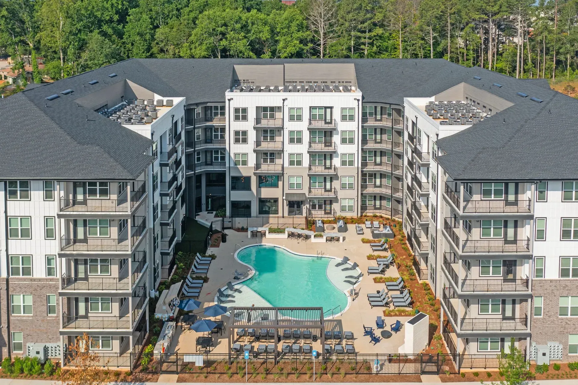 A large apartment building with a large swimming pool in the middle