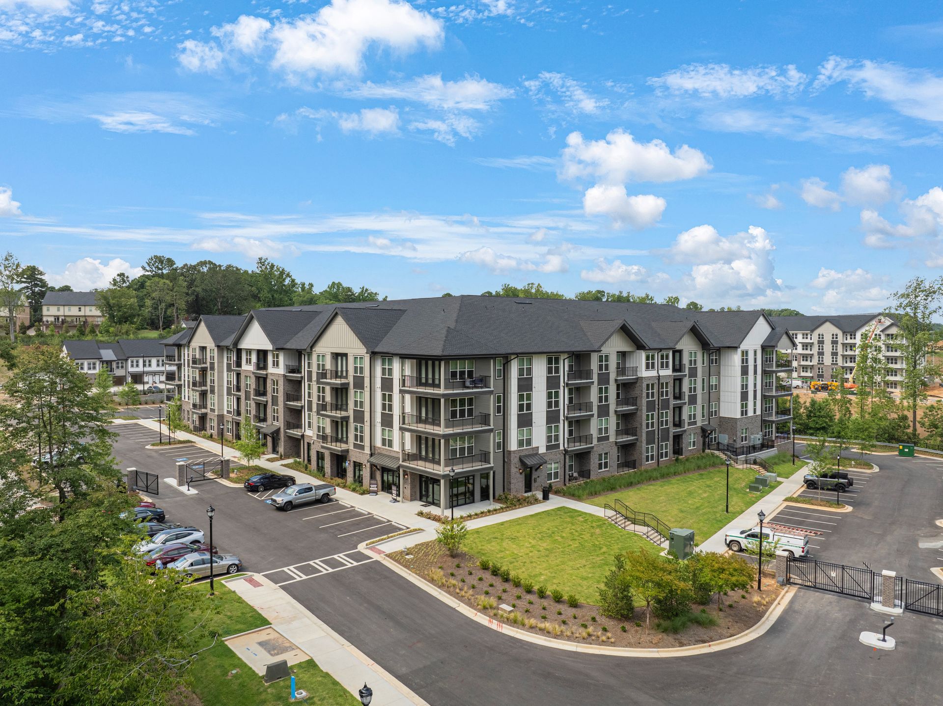 Modern apartment complex with gray and white facade under a blue sky.