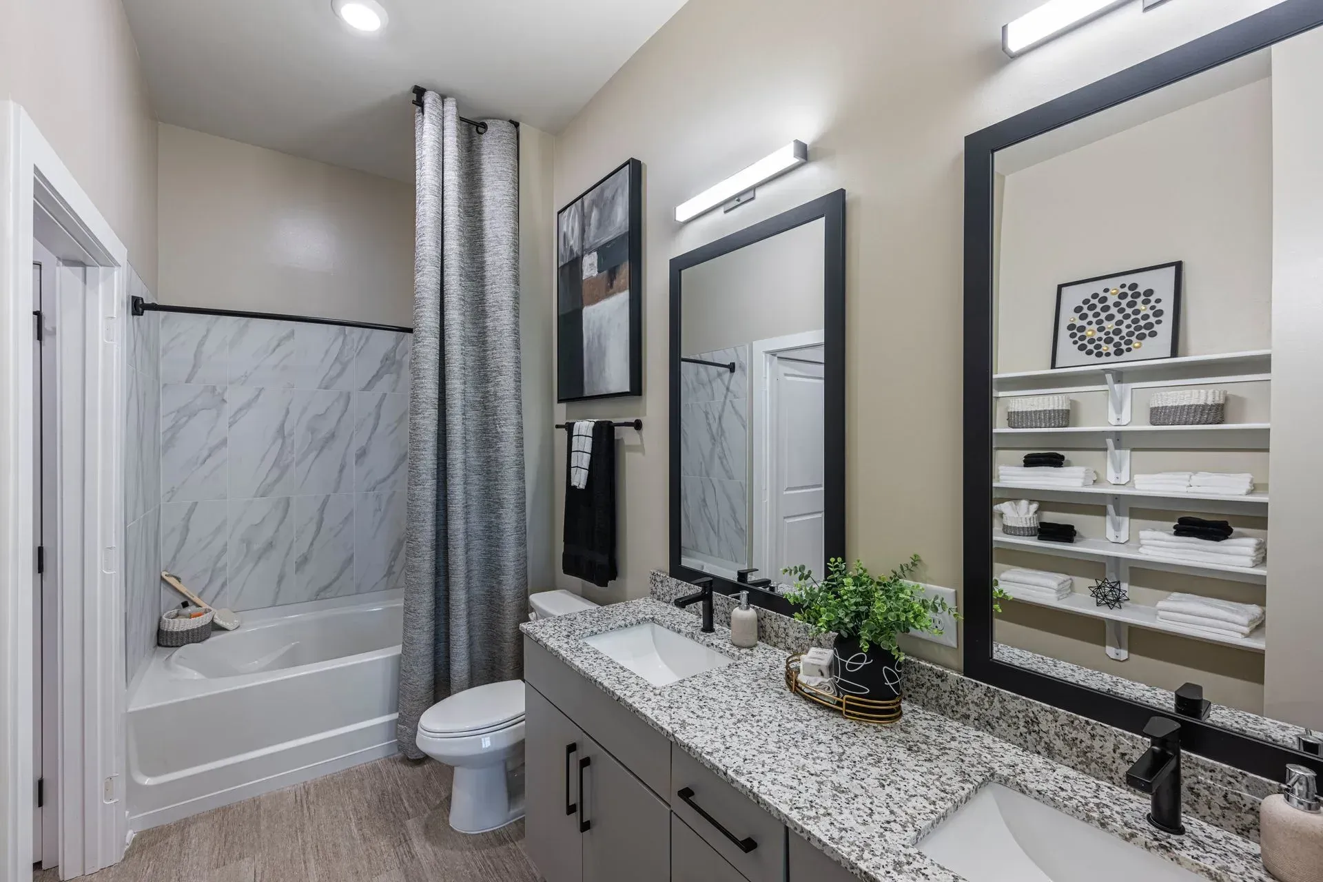 A bathroom with two sinks , a toilet , and a bathtub.