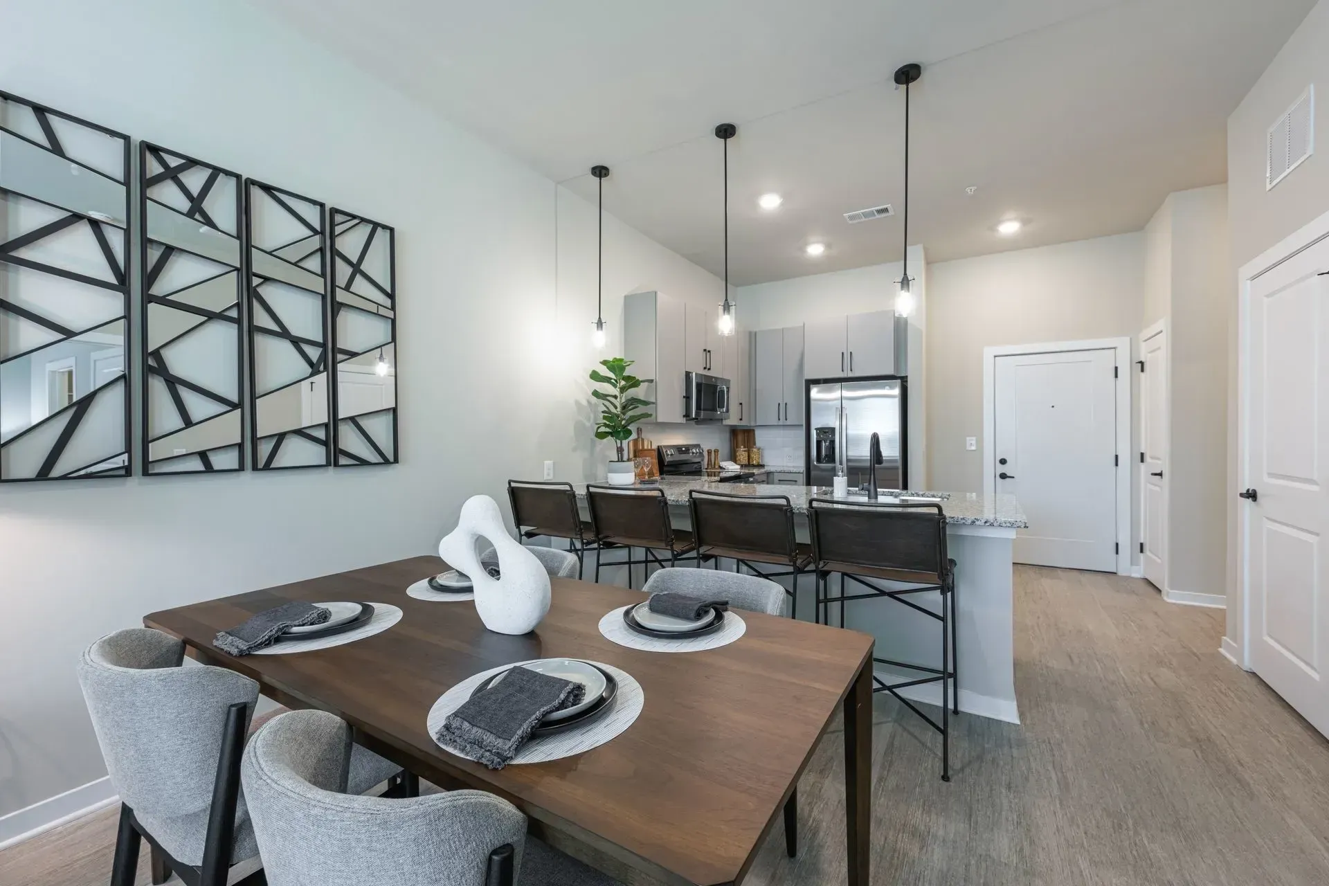 A dining room with a table and chairs and a kitchen