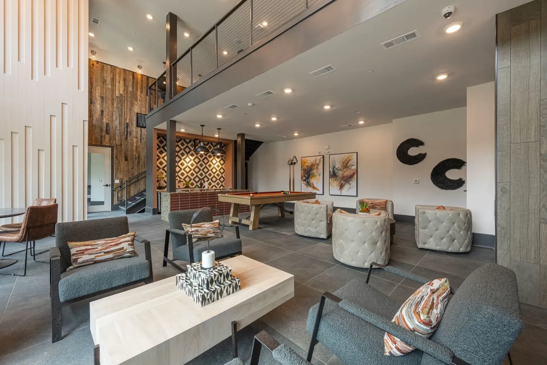 A living room with a pool table and chairs
