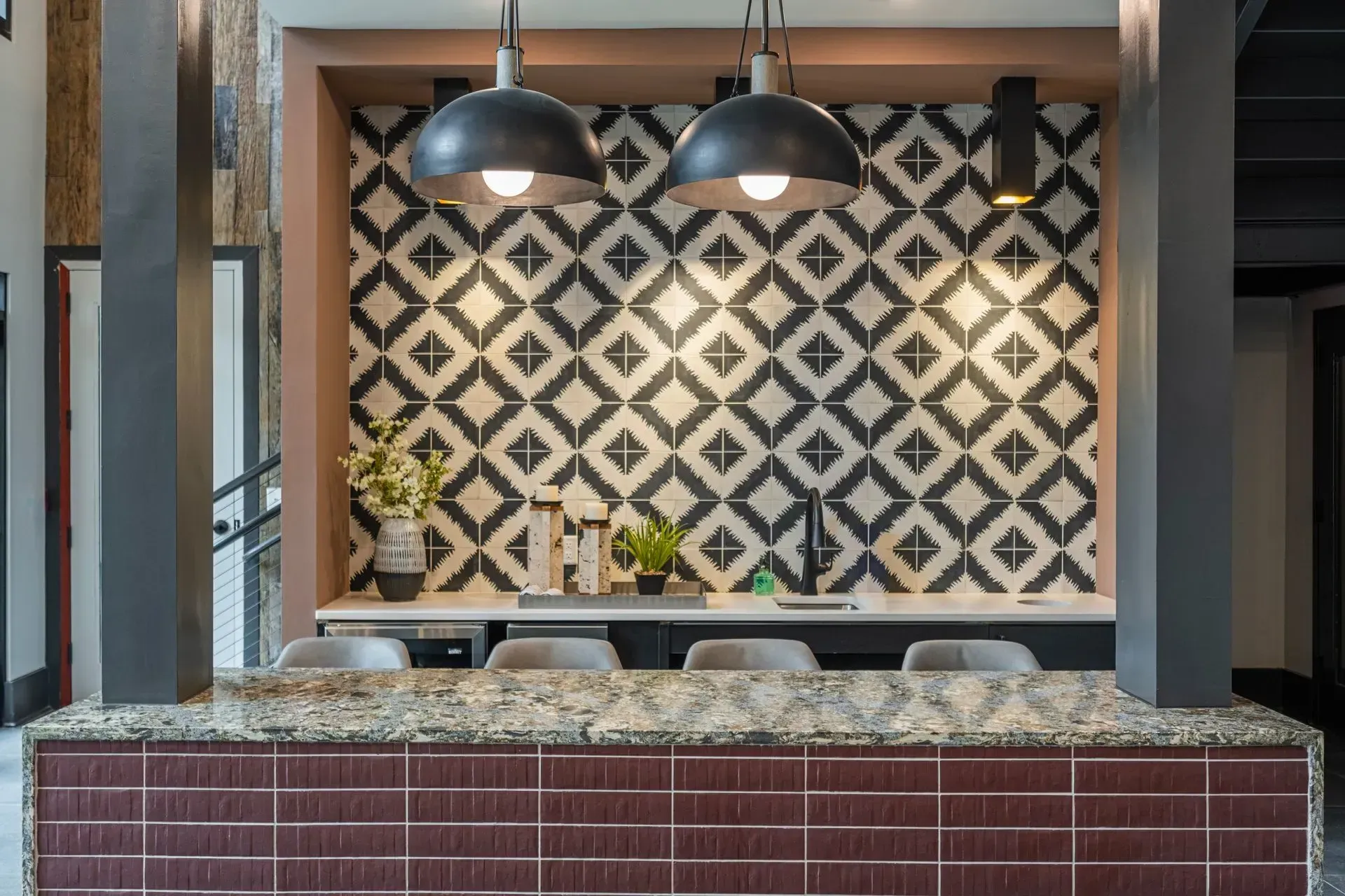 A kitchen counter with a black and white patterned wall behind it