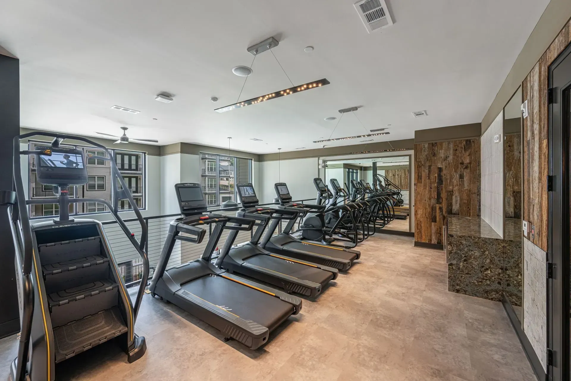 A gym with a lot of treadmills and stairs