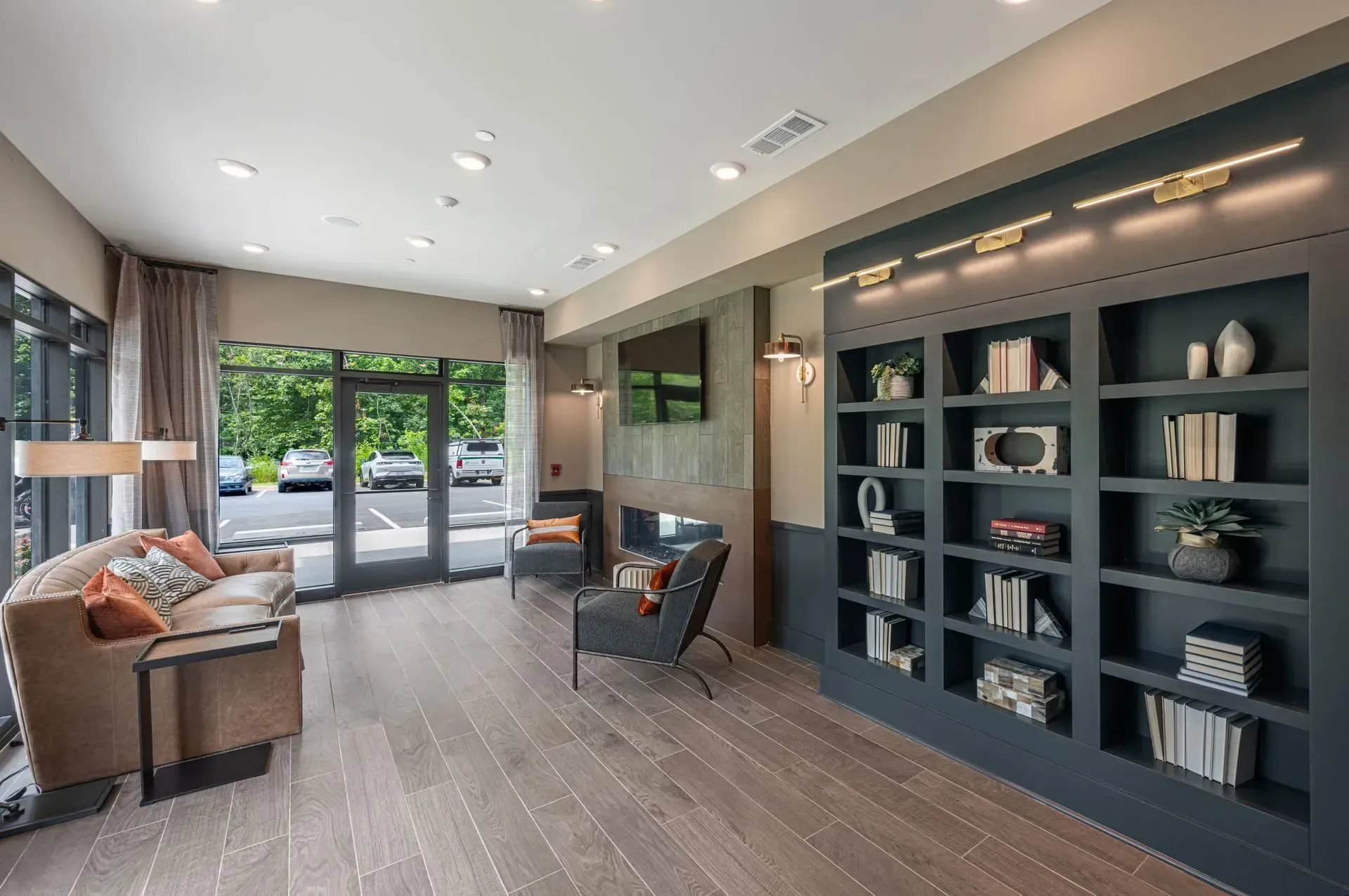 A living room with a couch , chairs , shelves and a television