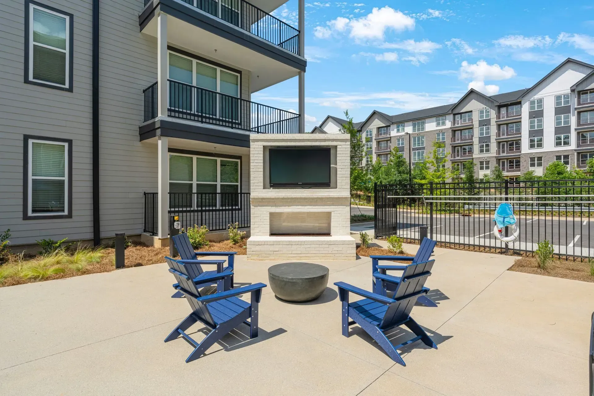 A patio with chairs and a fireplace in front of a building