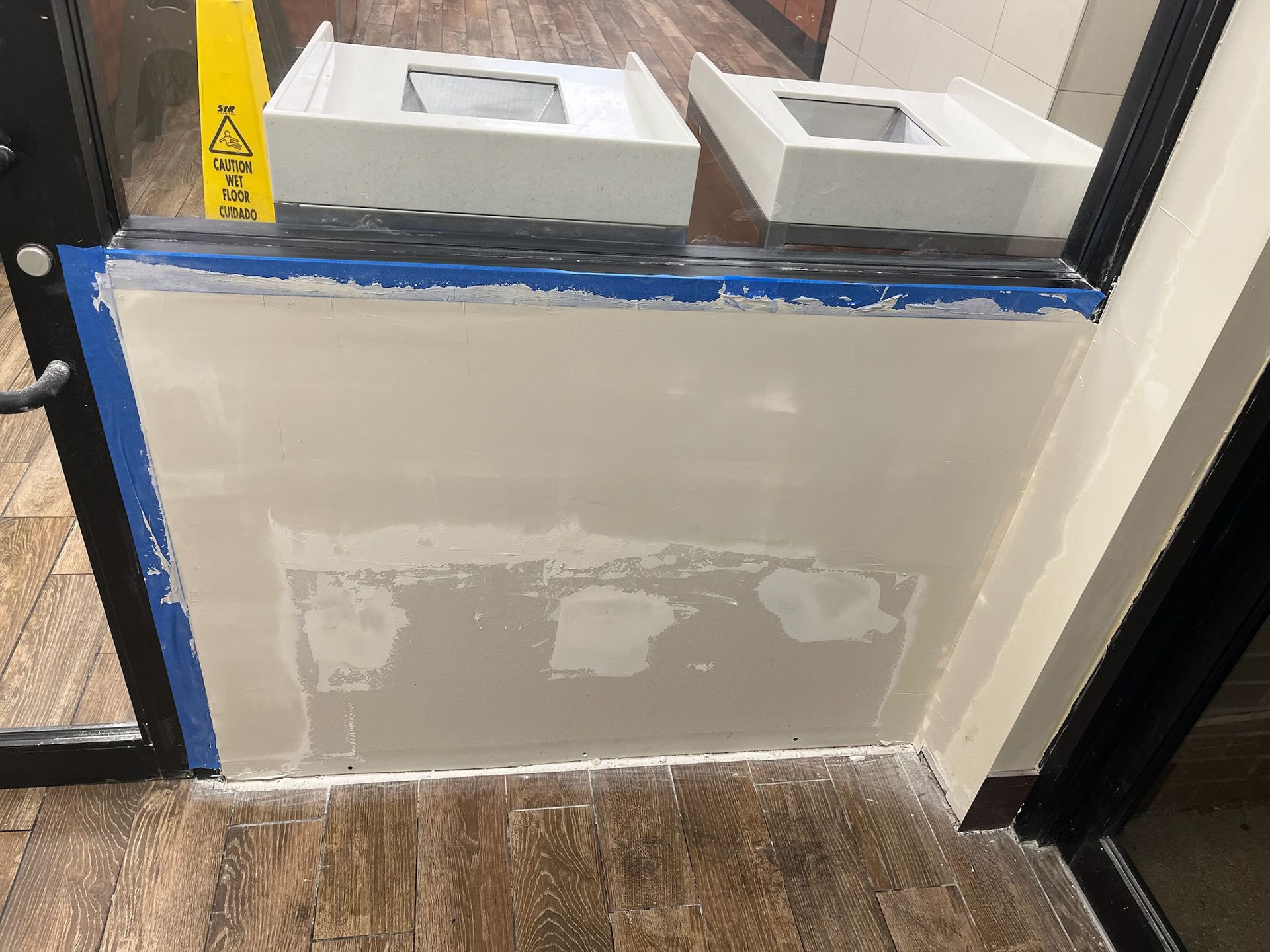 Wall construction at entryway. Wet plaster, blue tape, construction items.