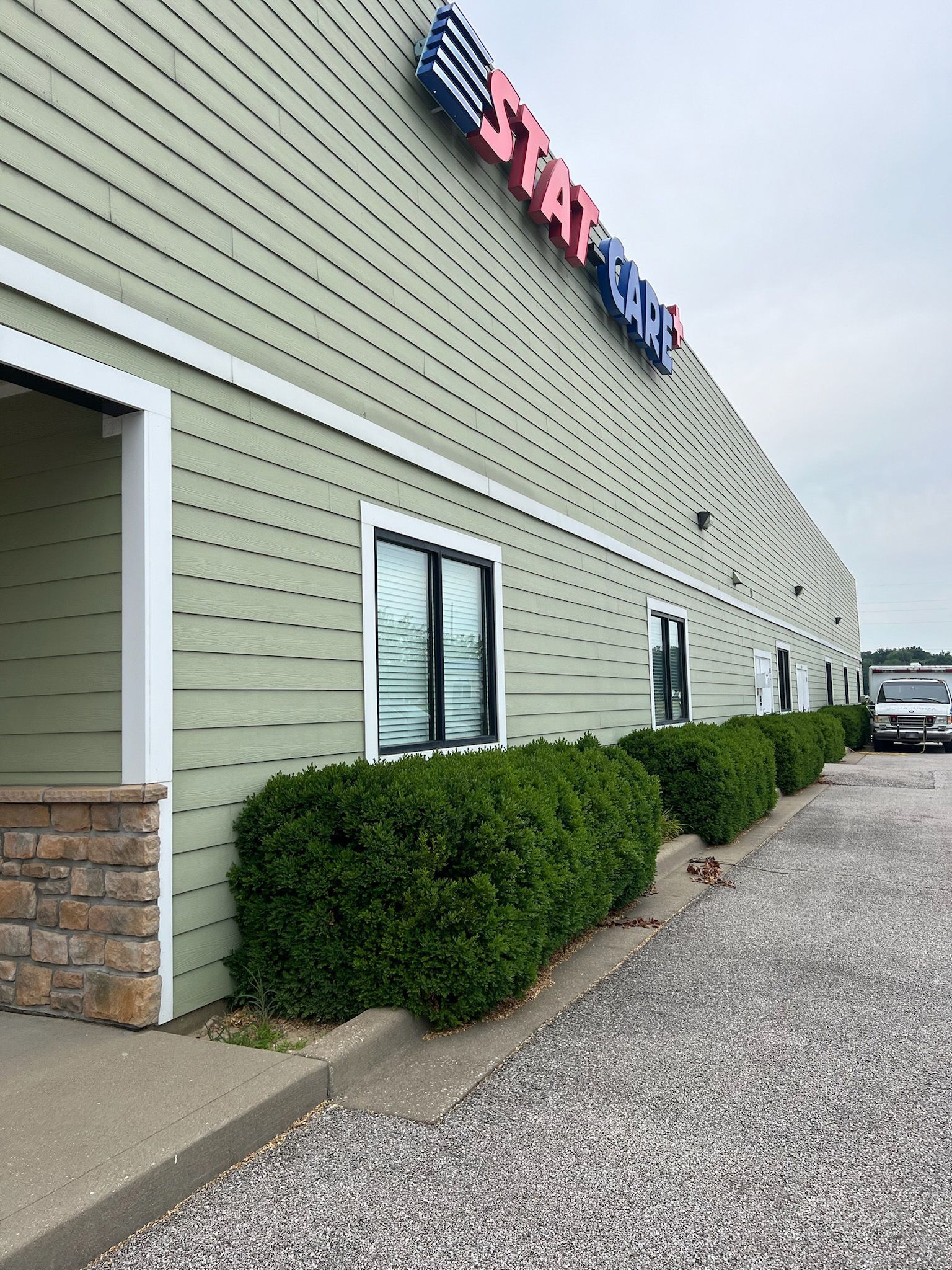 Exterior of a building with green siding, a sign that says 
