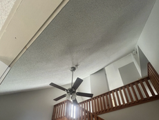 Ceiling with a fan, loft with railing, and white walls.