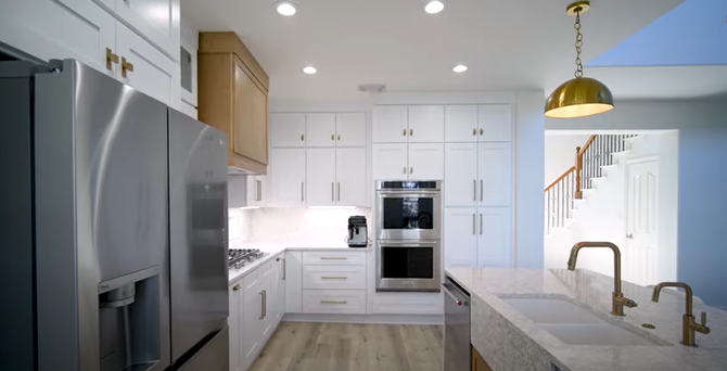 Modern kitchen with white cabinets and stainless steel appliances.