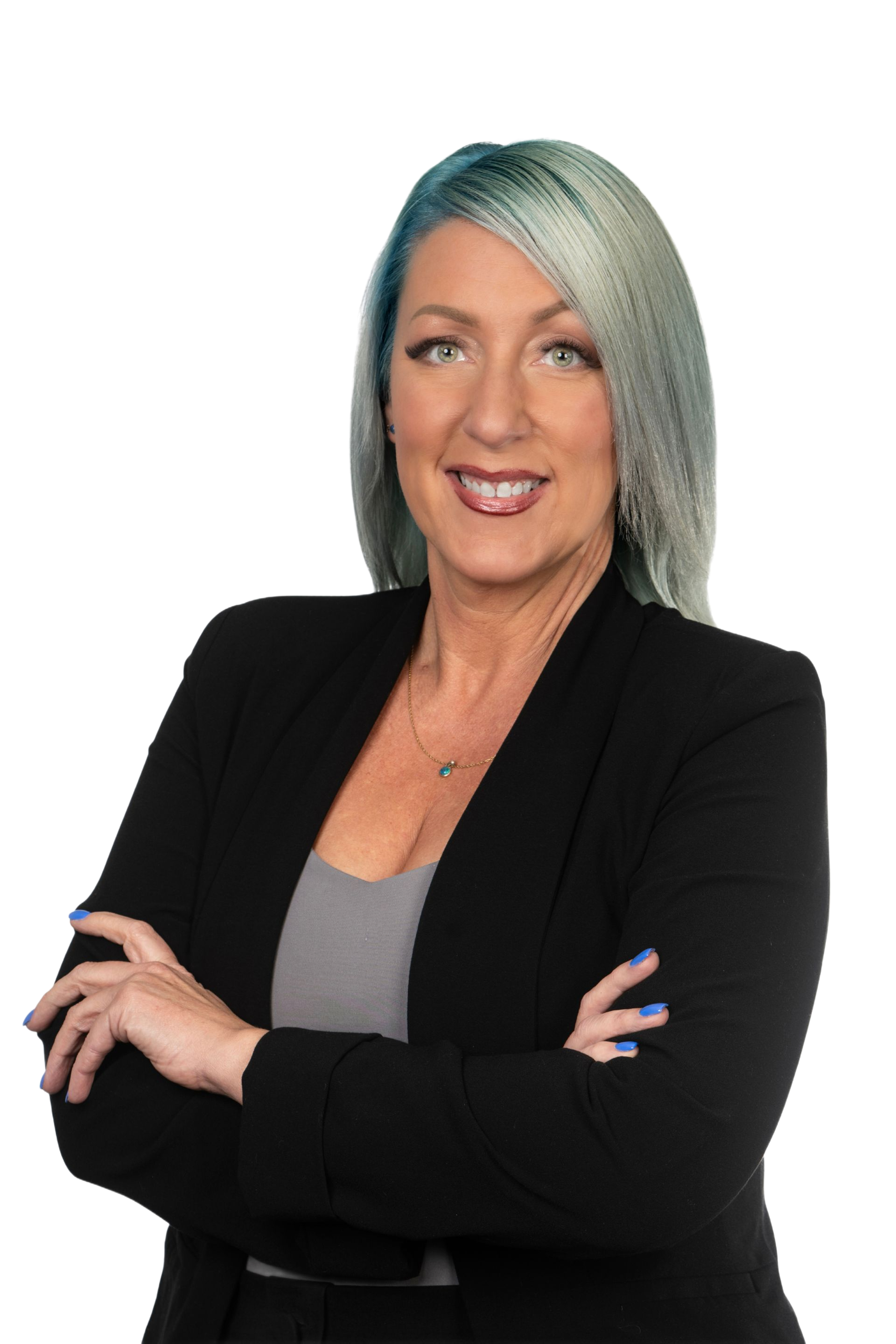 Woman with teal hair in black blazer, arms crossed, smiling.