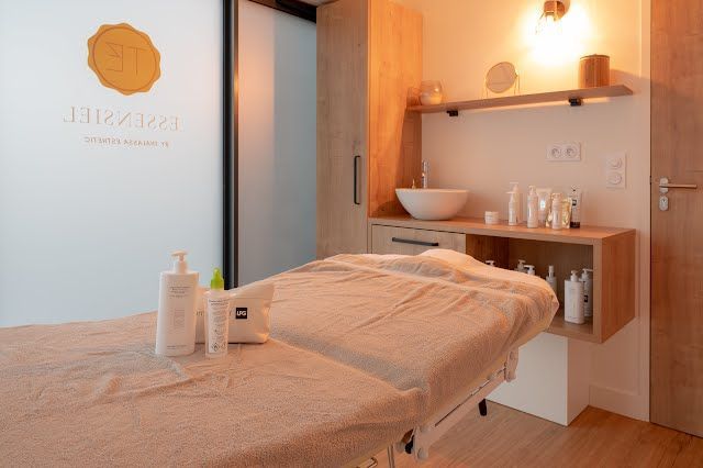 Une table de massage avec une serviette dessus dans une pièce avec un lavabo.