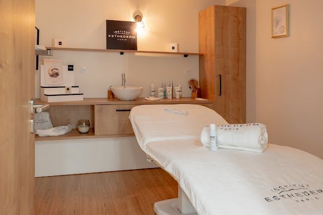 Une salle de spa avec une table de massage et un lavabo