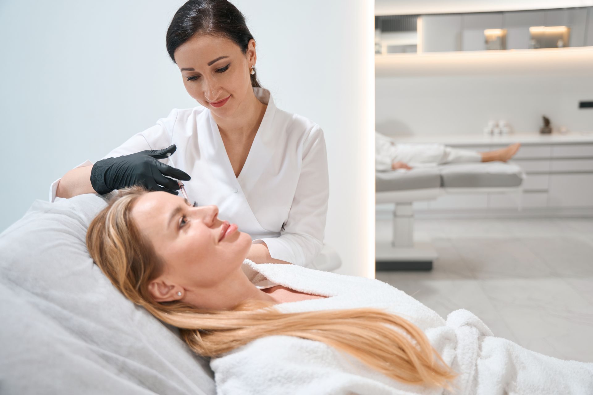 A woman is getting a facial treatment at a beauty salon.