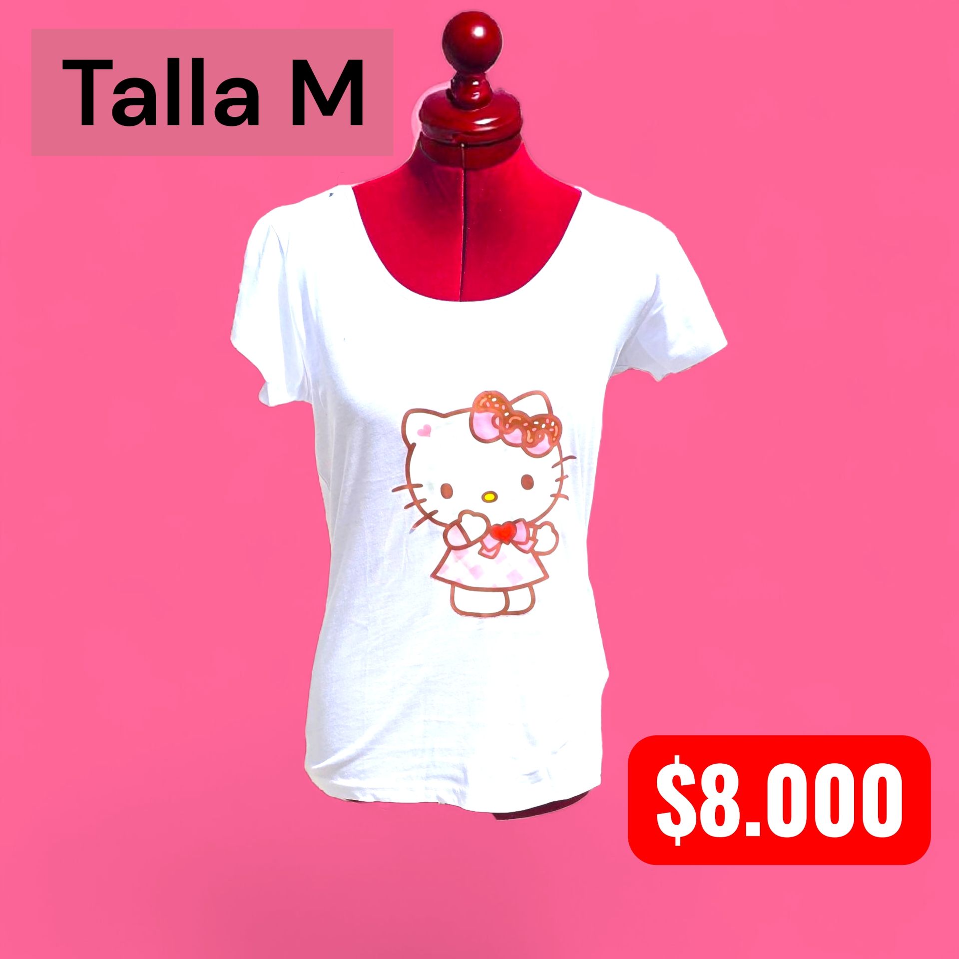 Mujer con camiseta blanca con estampado de Hello Kitty y falda vaquera, de pie al aire libre.