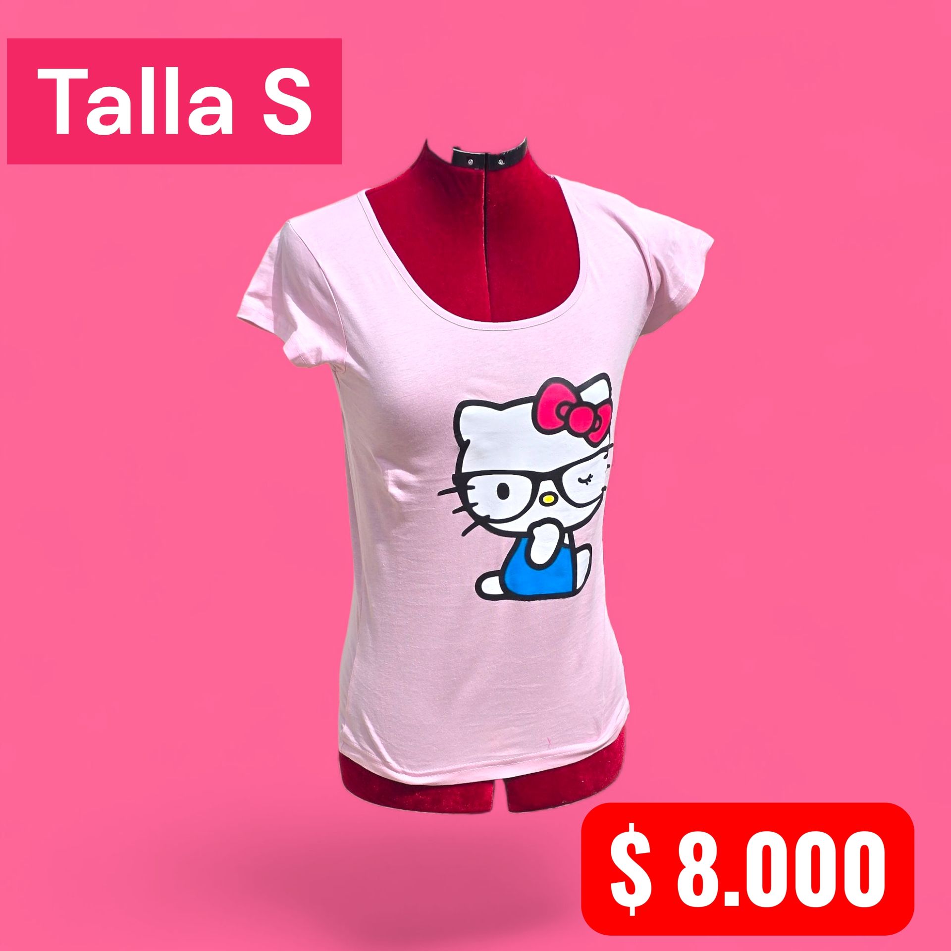 Una mujer rapada, vestida con una camiseta rosa de Hello Kitty, vaqueros rotos y zapatillas, está de pie en un callejón.