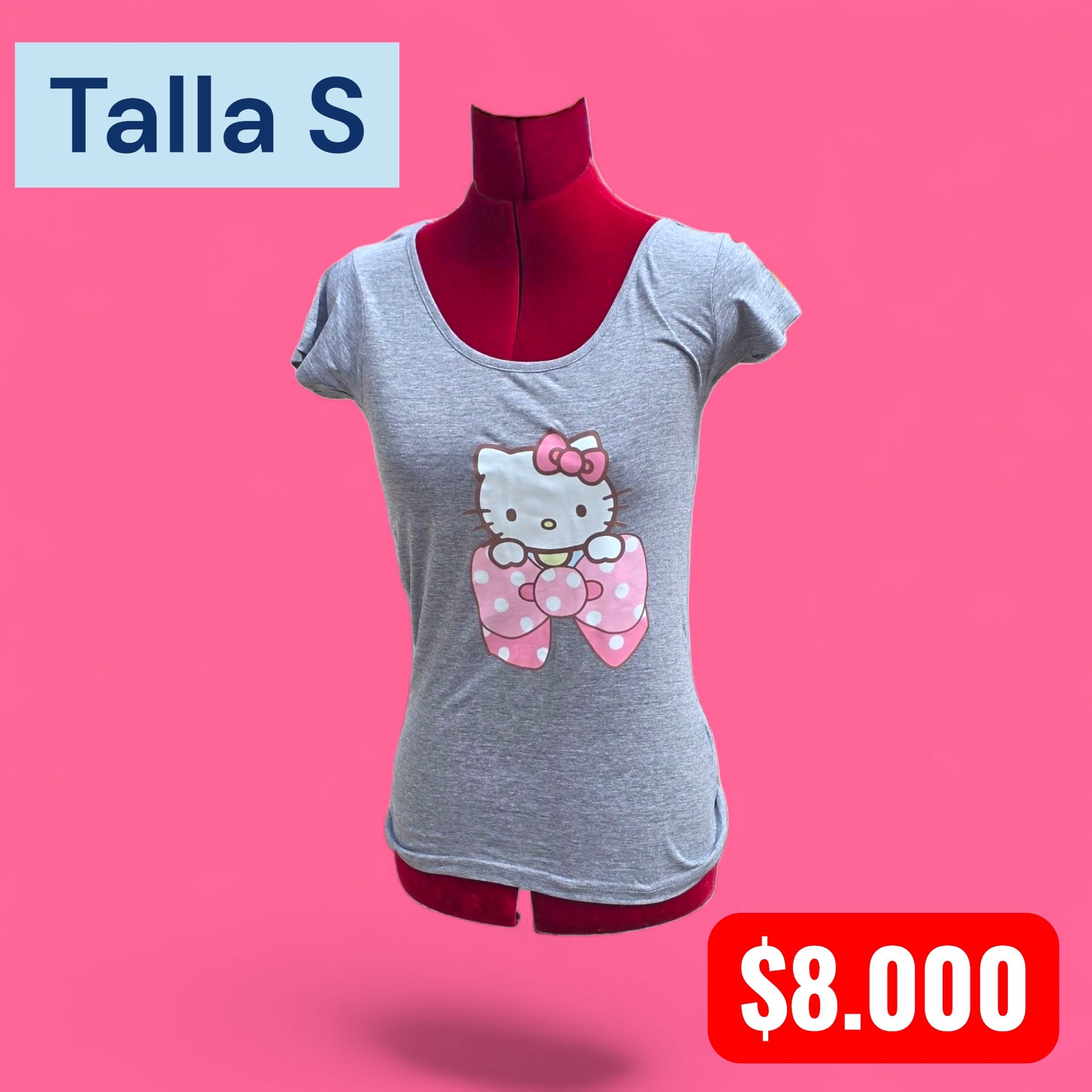 Una mujer con la cabeza rapada lleva una camiseta de Hello Kitty y una falda de cuadros roja al aire libre.