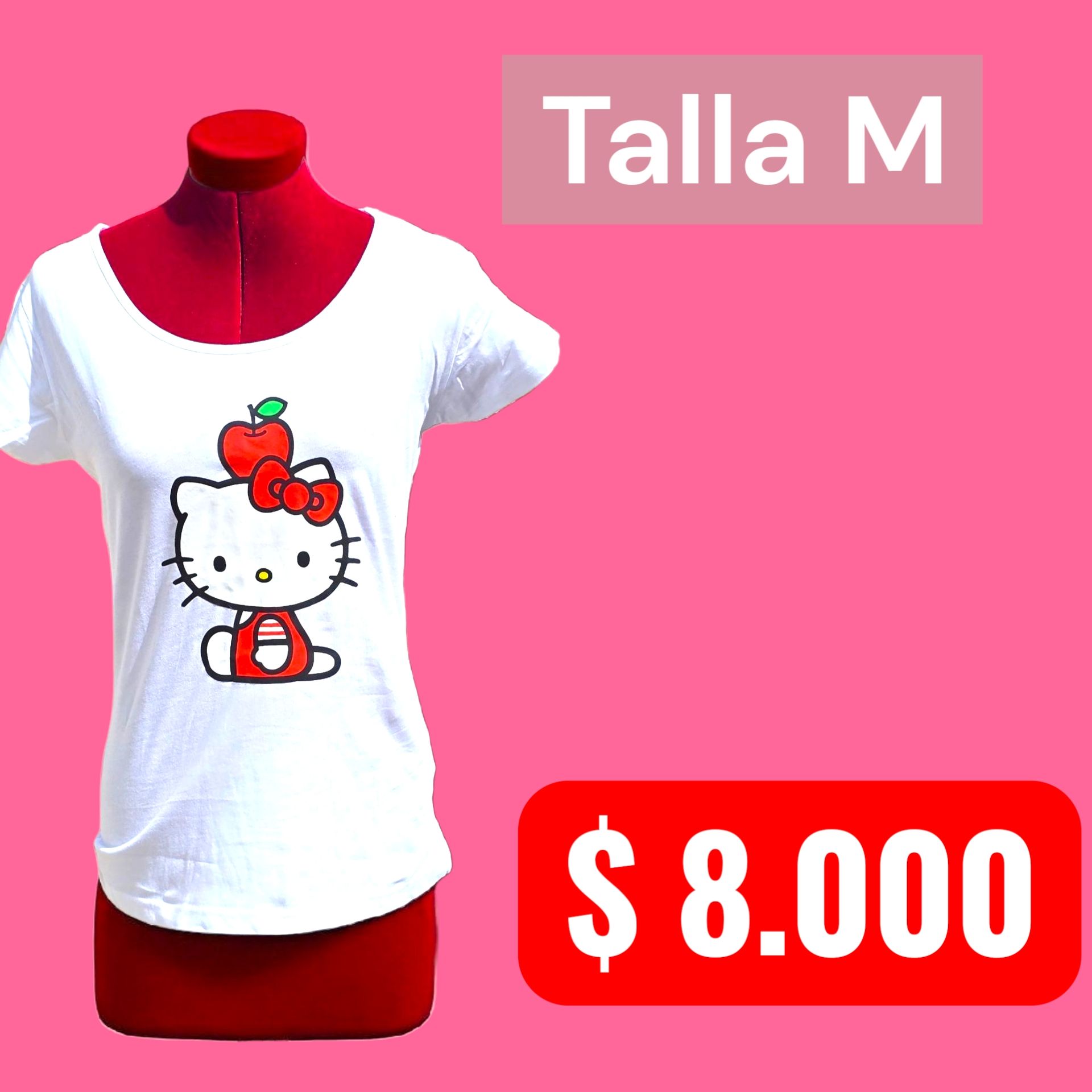 Mujer con camiseta blanca con estampado de manzana de Hello Kitty, de pie junto a la ventana de una cafetería.