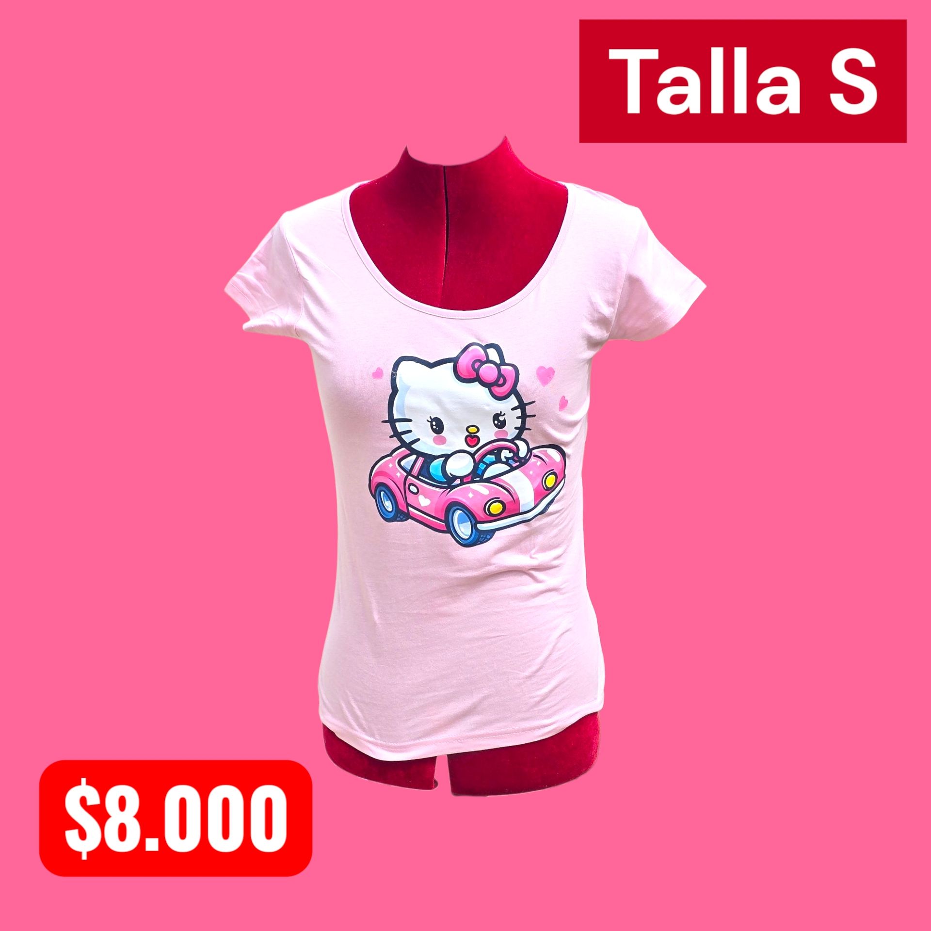 Mujer rapada con camiseta rosa de Hello Kitty, buzo gris y zapatillas, de pie en el exterior con las manos en los bolsillos.