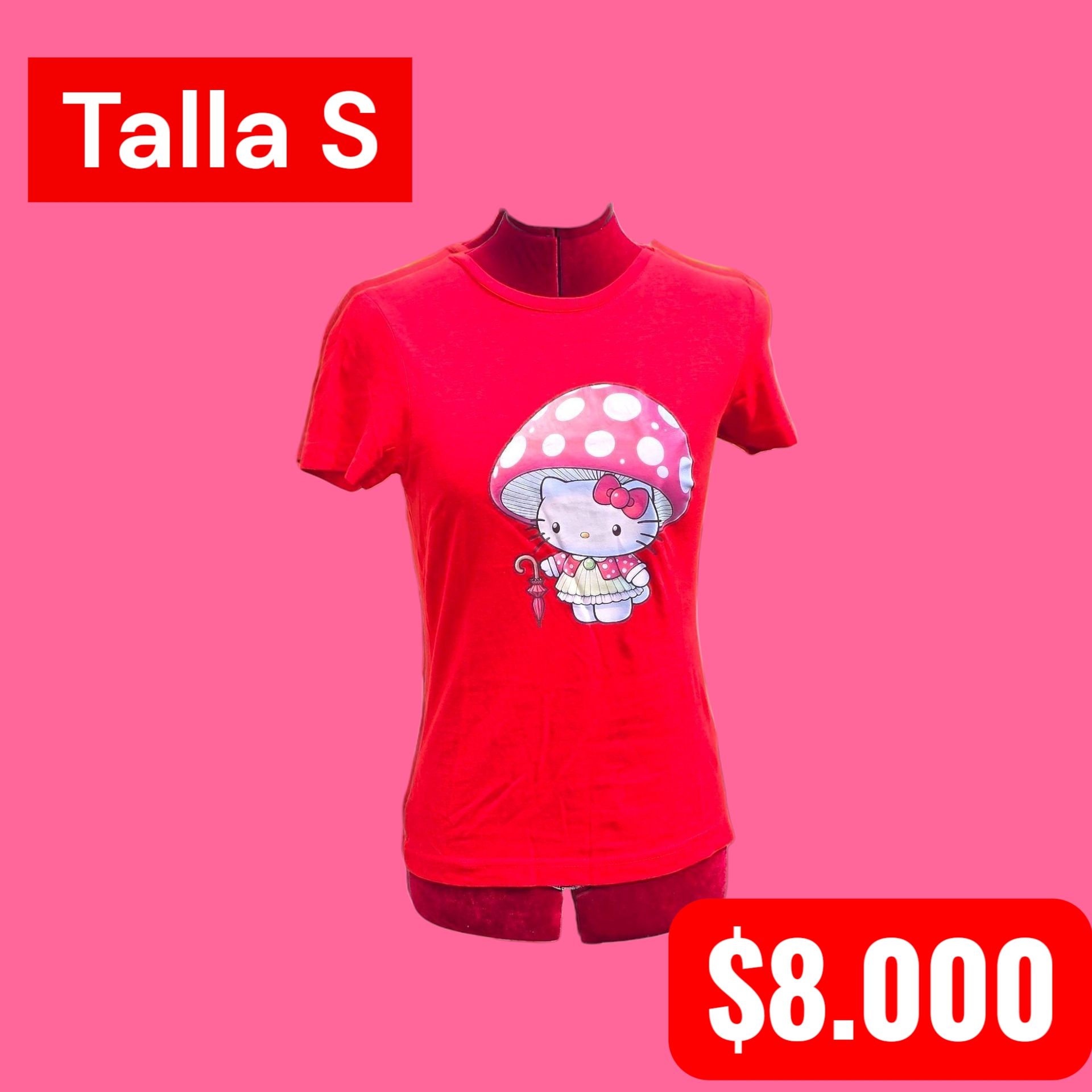 Persona con la cabeza rapada, vestida de rojo y con pantalones a rayas, de pie en un callejón.