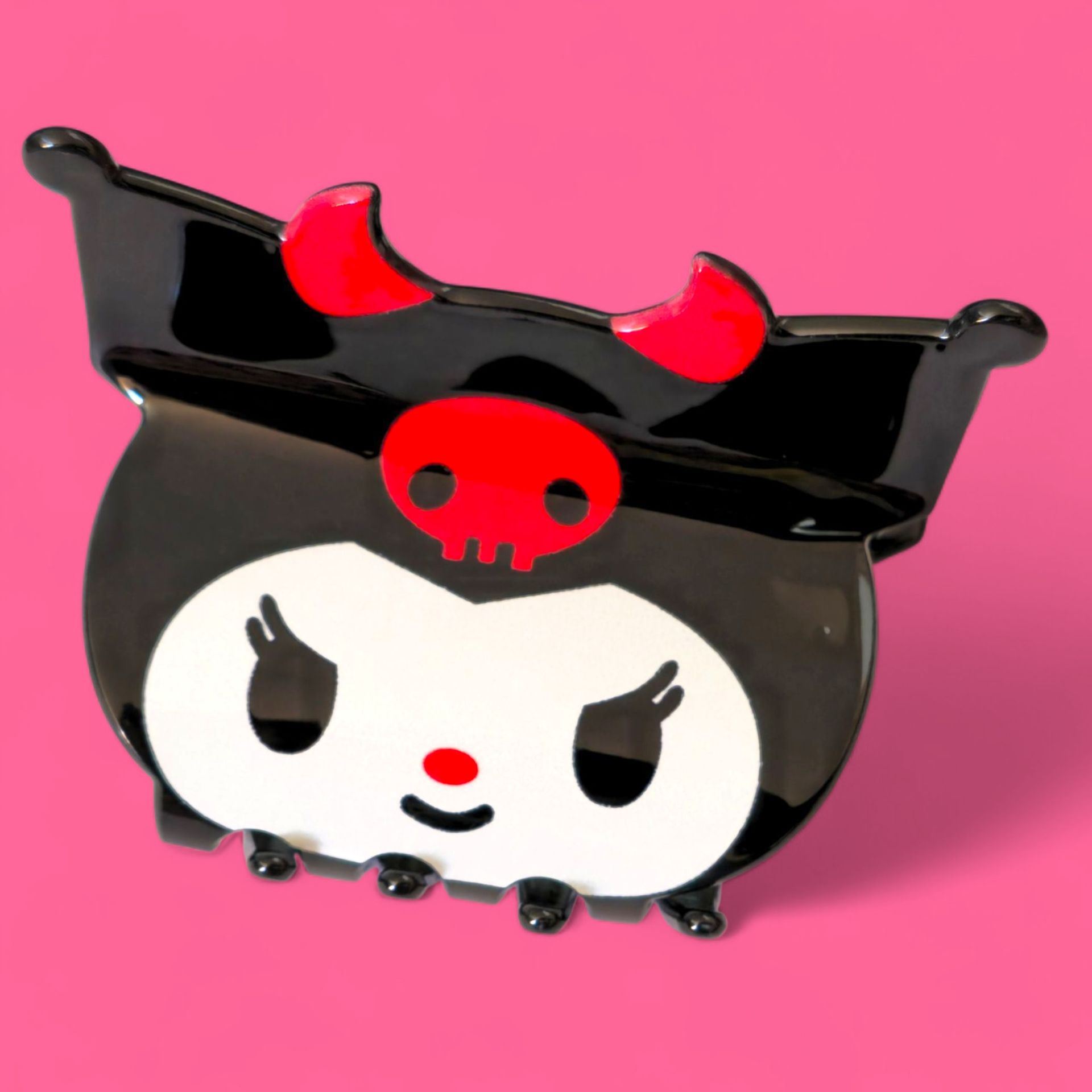 Pin esmaltado de Kuromi con detalles en negro, rojo y blanco, sobre fondo rosa.