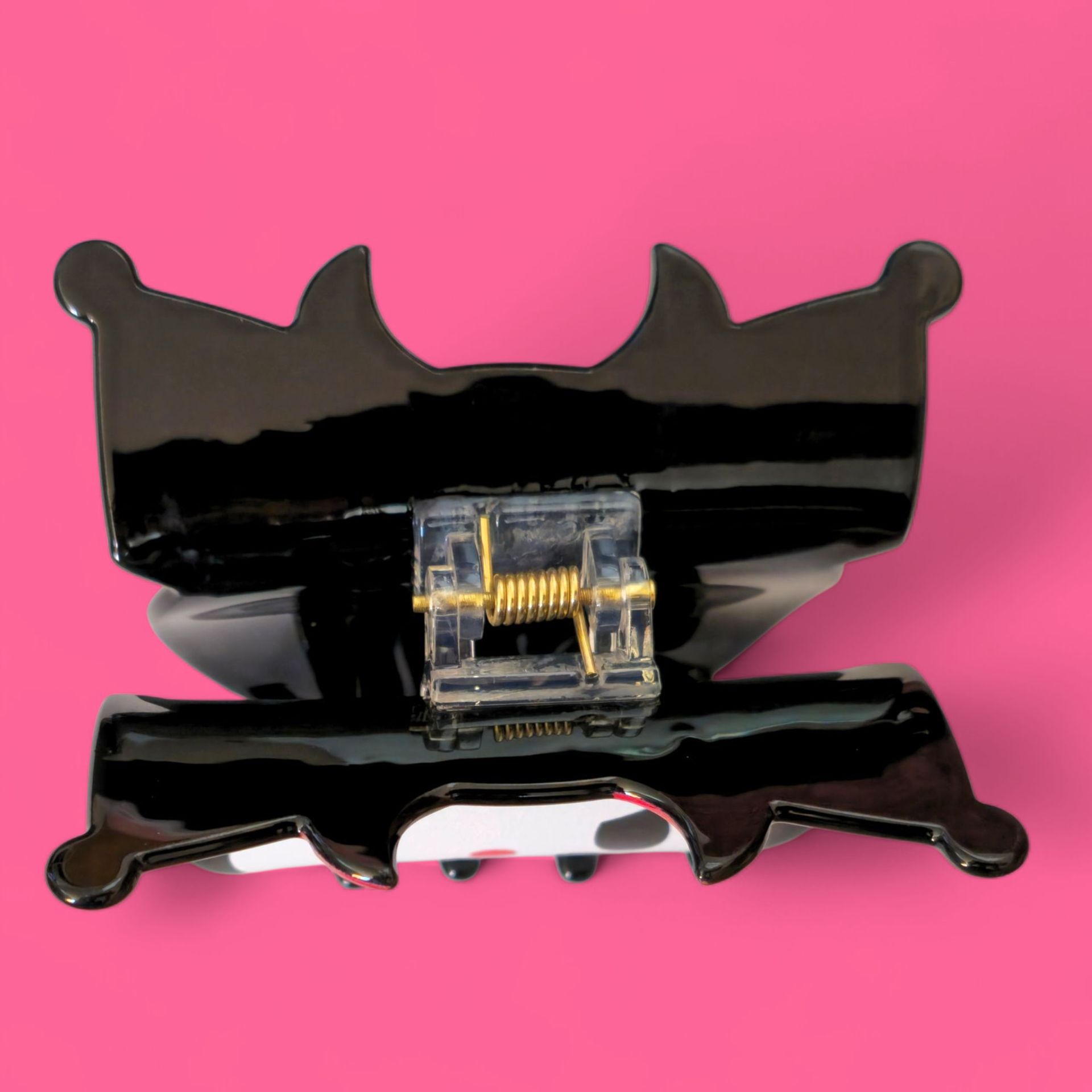 Pin esmaltado de Kuromi con detalles en negro, rojo y blanco, sobre fondo rosa.