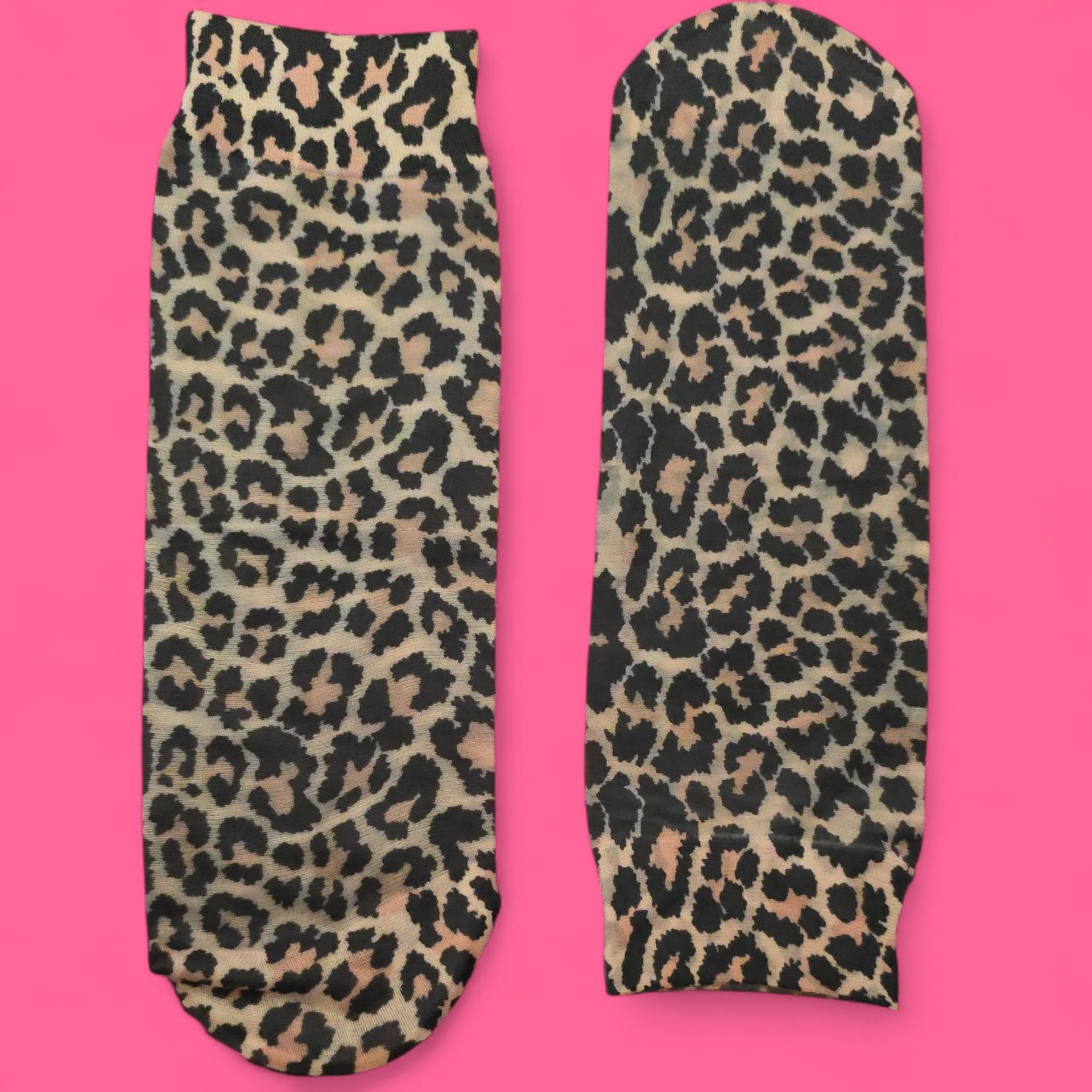 Par de calcetines con estampado de leopardo sobre fondo rosa.