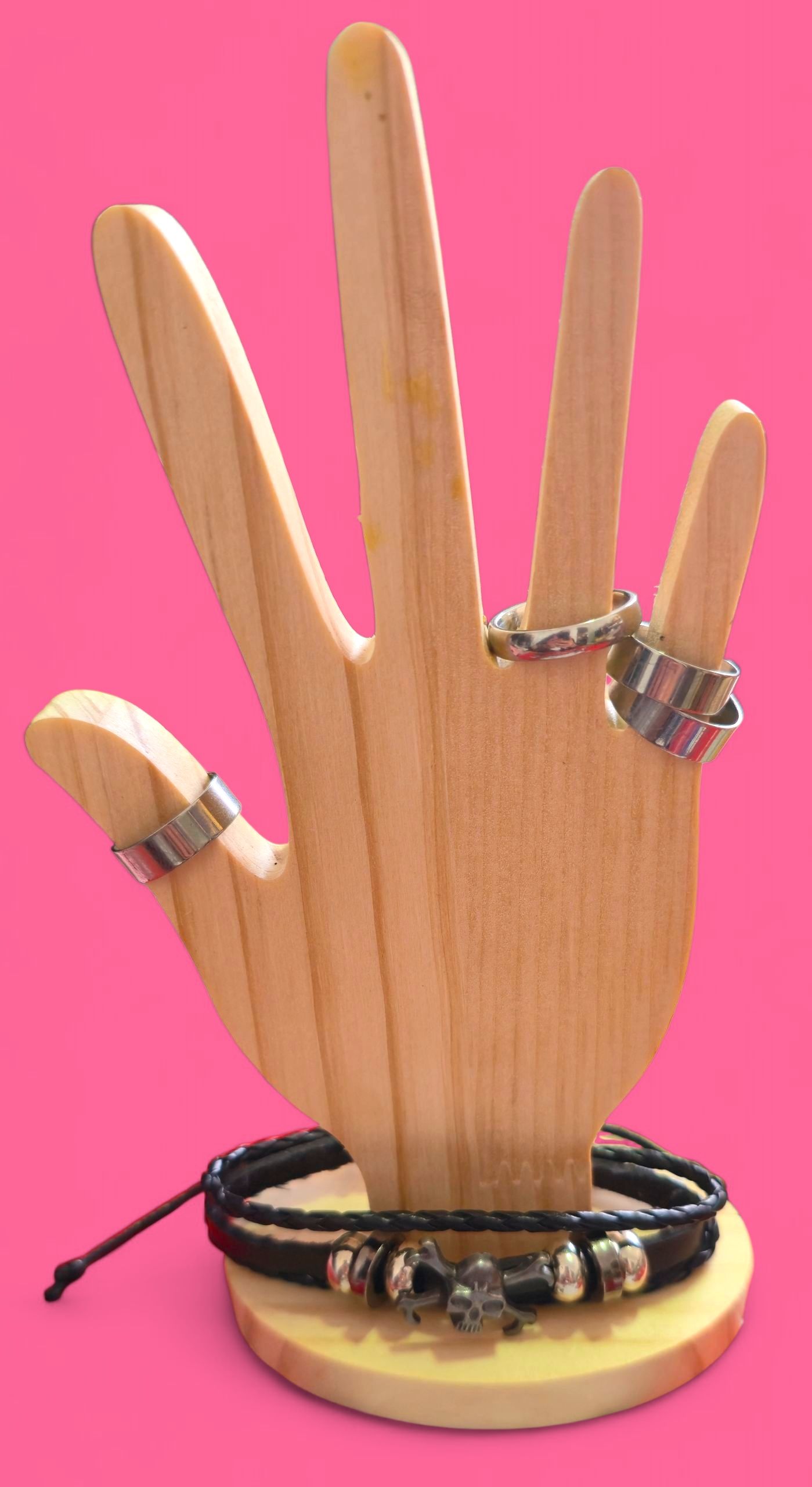 Pulsera de cuero negro con dije de calavera sobre expositor de madera.