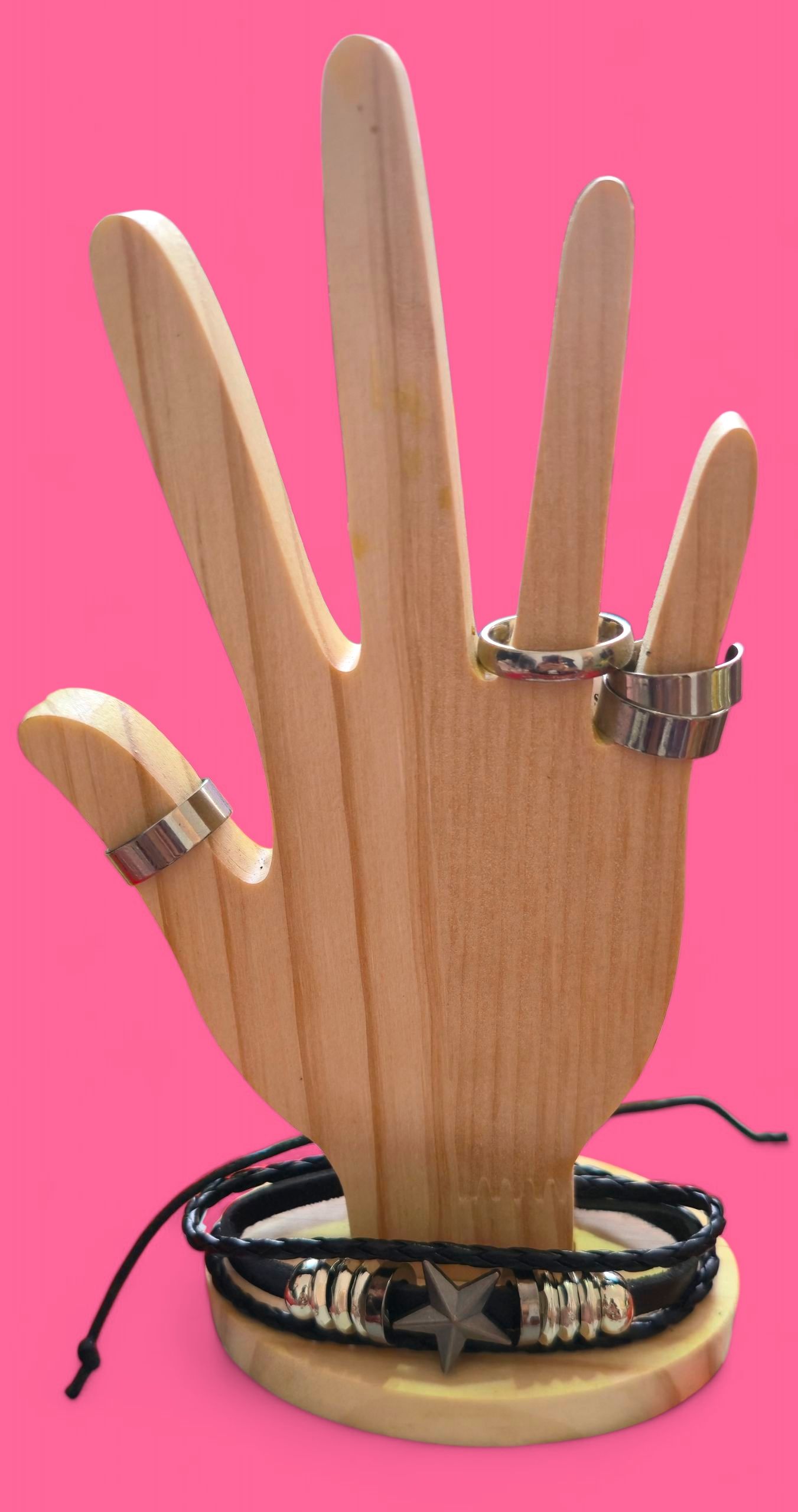 Pulsera de cuero negro con detalles plateados y una estrella sobre soporte de madera.