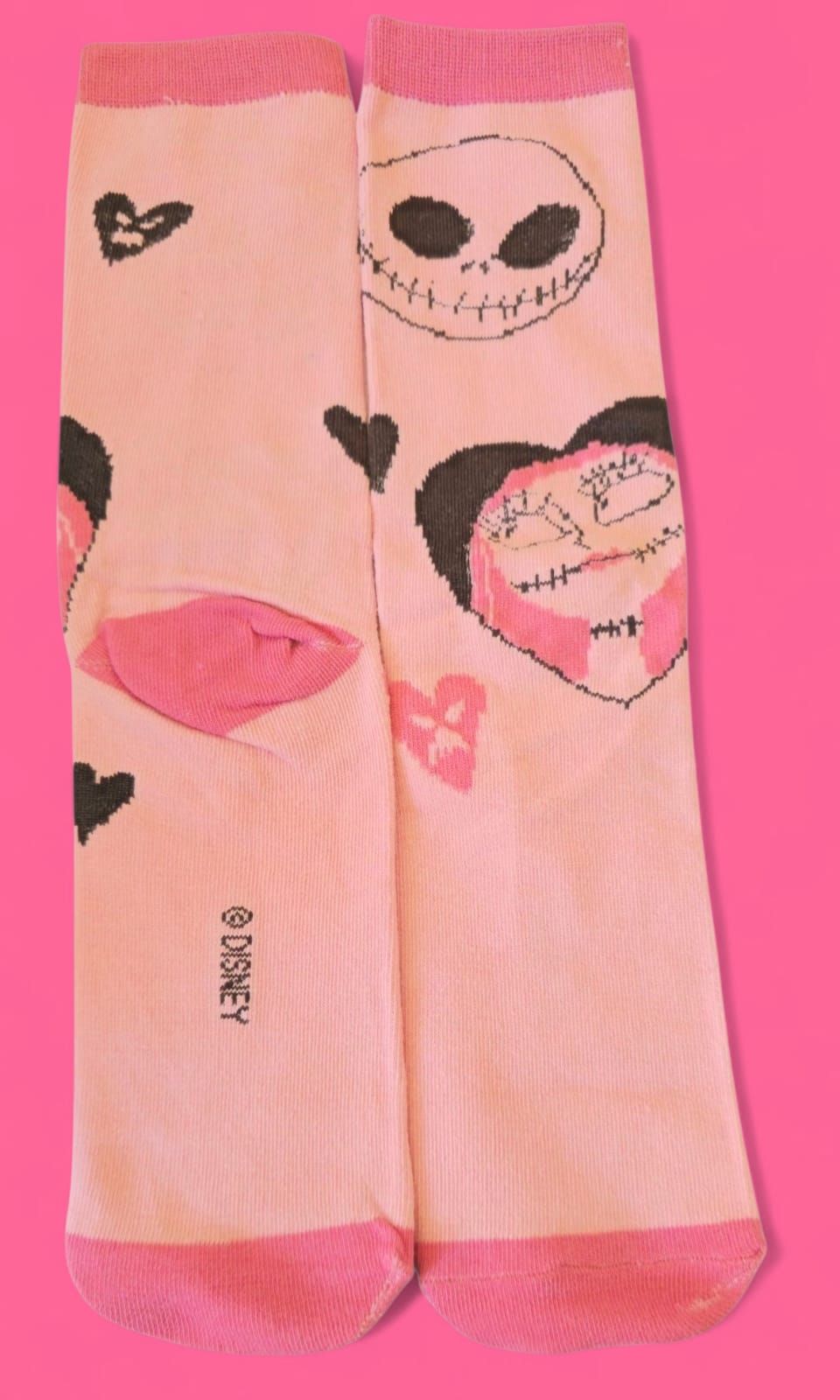 Calcetines rosas con Jack Skellington, corazones y el logotipo de Disney.