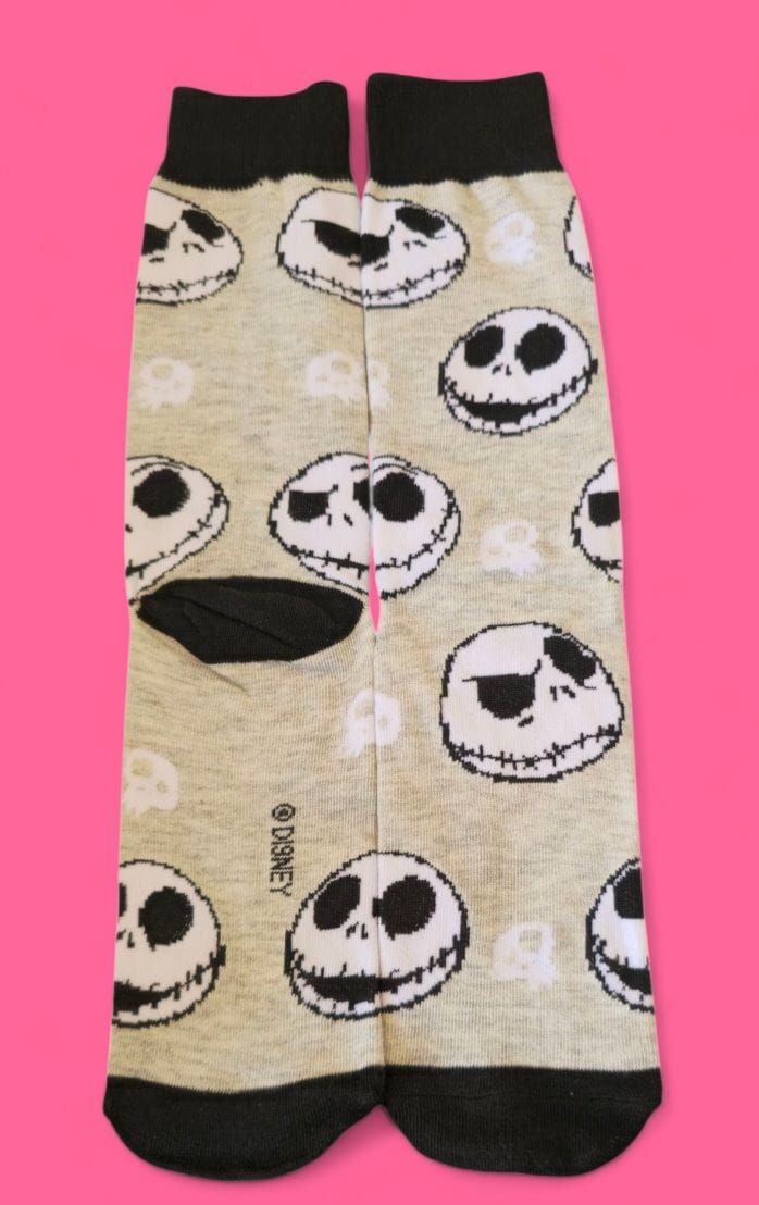 Par de calcetines con caras de Jack Skellington repetidas sobre fondo gris claro, puños y punteras negras.