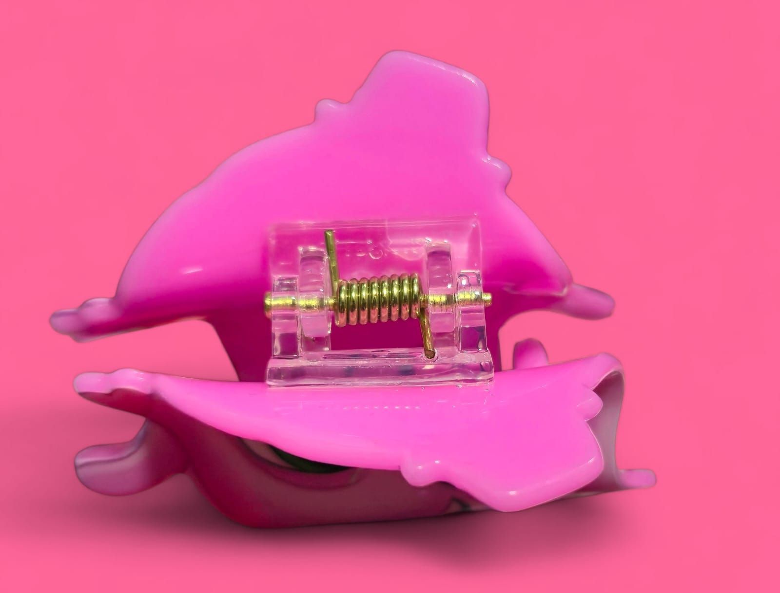 Personaje de dibujos animados rosa con grandes ojos verdes y expresión sonriente.