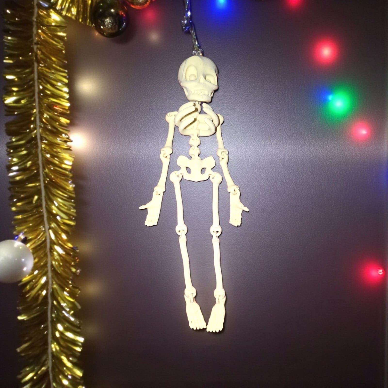 Adorno navideño de esqueleto colgante con luces y guirnaldas.