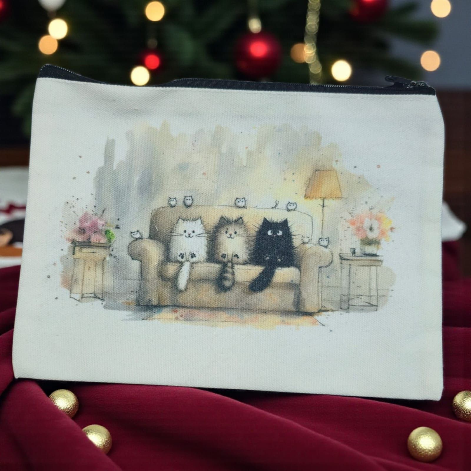 Bolsa de lona con acuarela de tres gatos en un sofá; ambiente navideño.