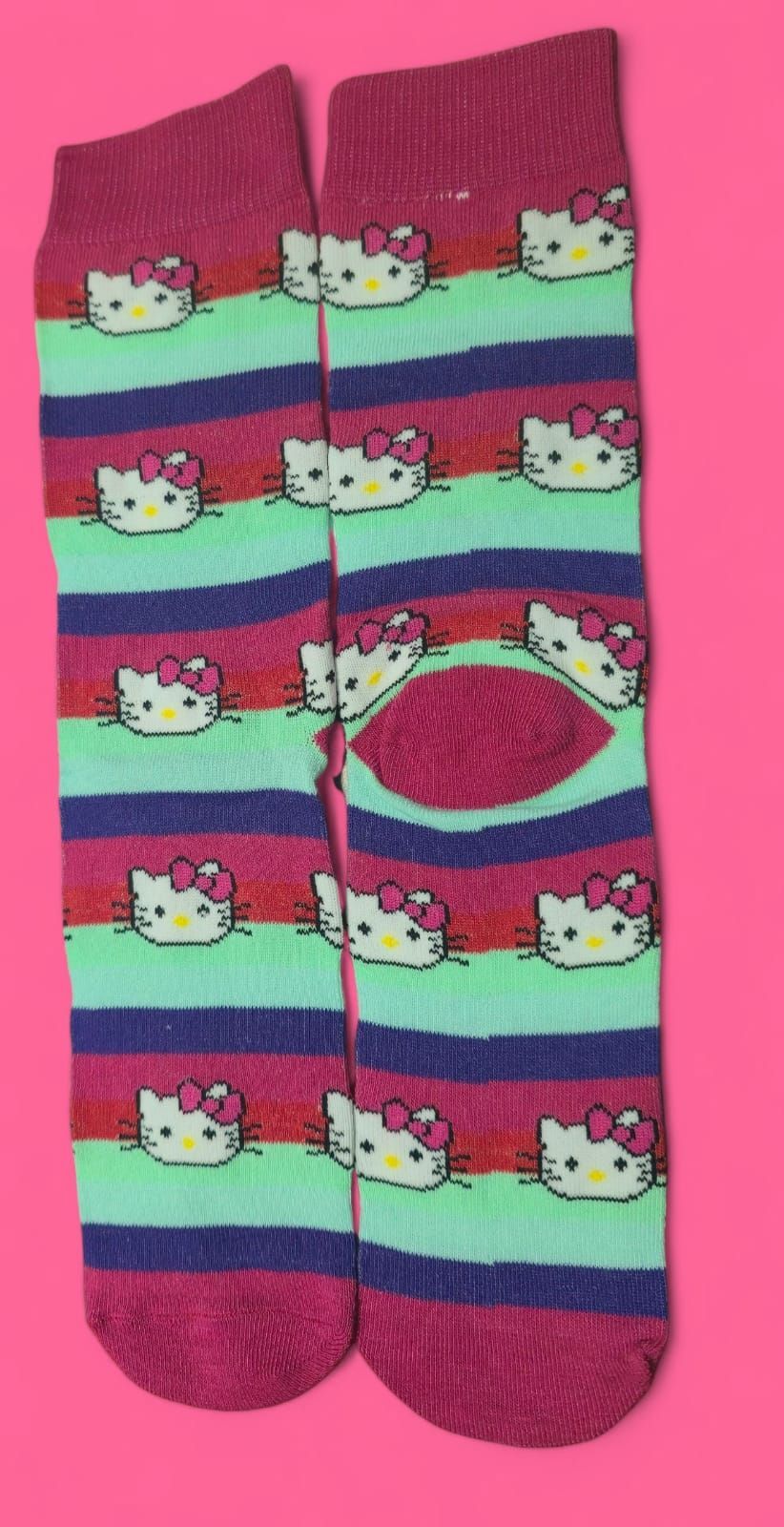 Un par de calcetines de Hello Kitty con rayas rosas, azules y verdes.