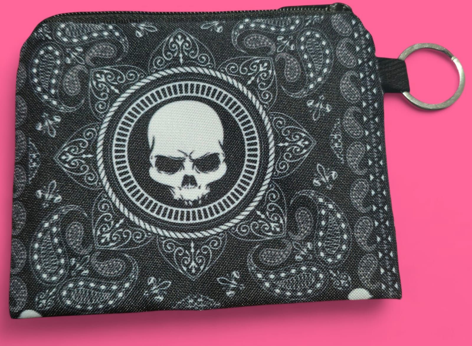 Monedero negro con diseño de calavera y estampado paisley.