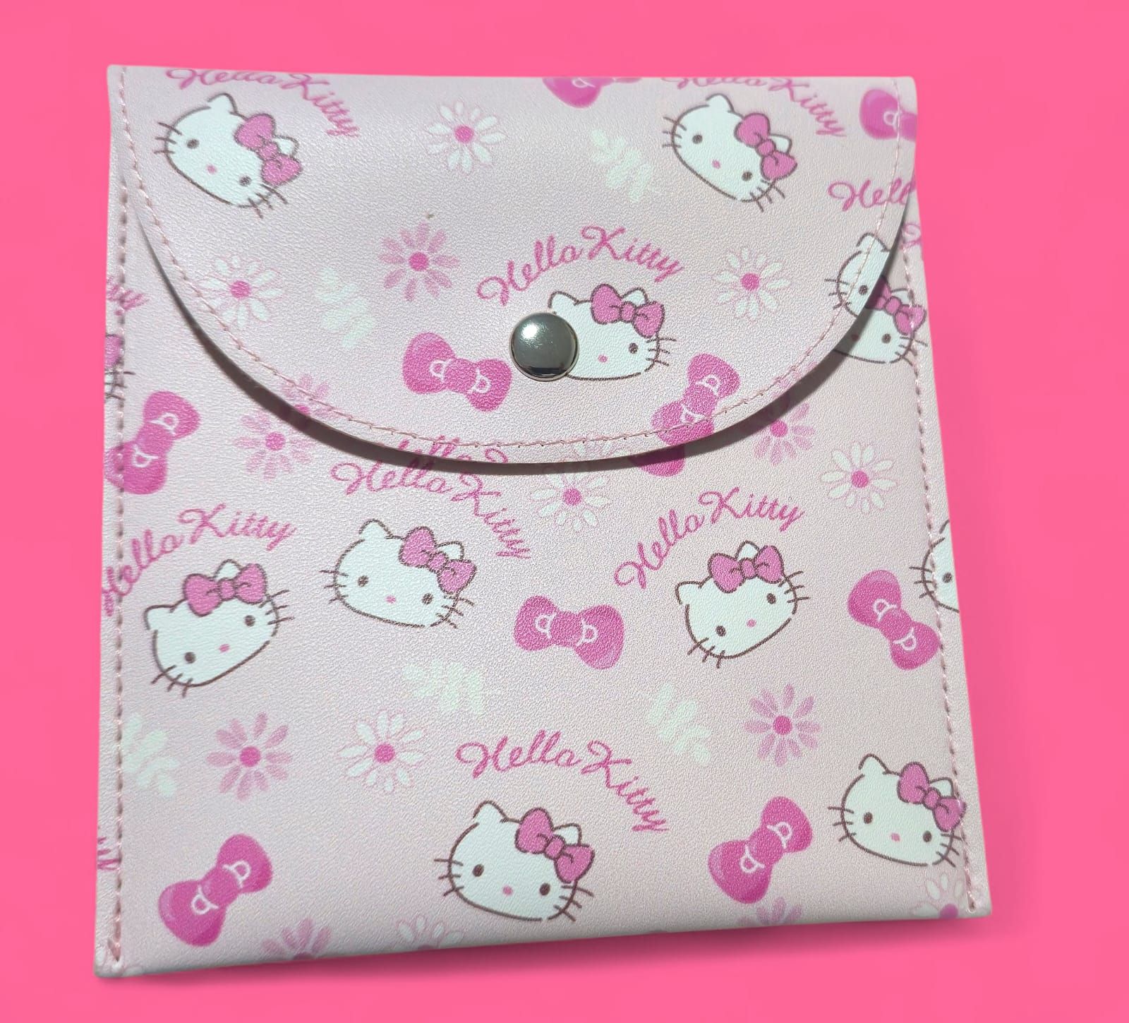 Monedero rosa de Hello Kitty con cierre a presión, decorado con el personaje, lazos y margaritas.